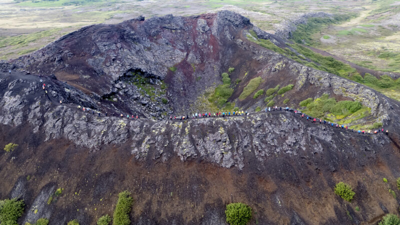 Gjörningur og táknræn keðja á toppi gígsins í Búrfellsgjáþegar félagskonur gengu Búrfellsgjánna og beindu kastljósinu að nýrri nefnd, New Icelanders FKA eða Nýir íslendingar. / Dróna mynd ONNO ehf.